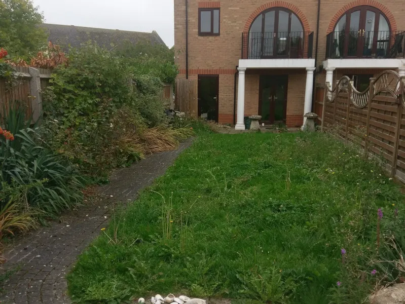 The Low-Maintenance, Bee-Friendly Garden — Before Overgrown grass and flowerbeds, this time looking towards the house and its balcony
