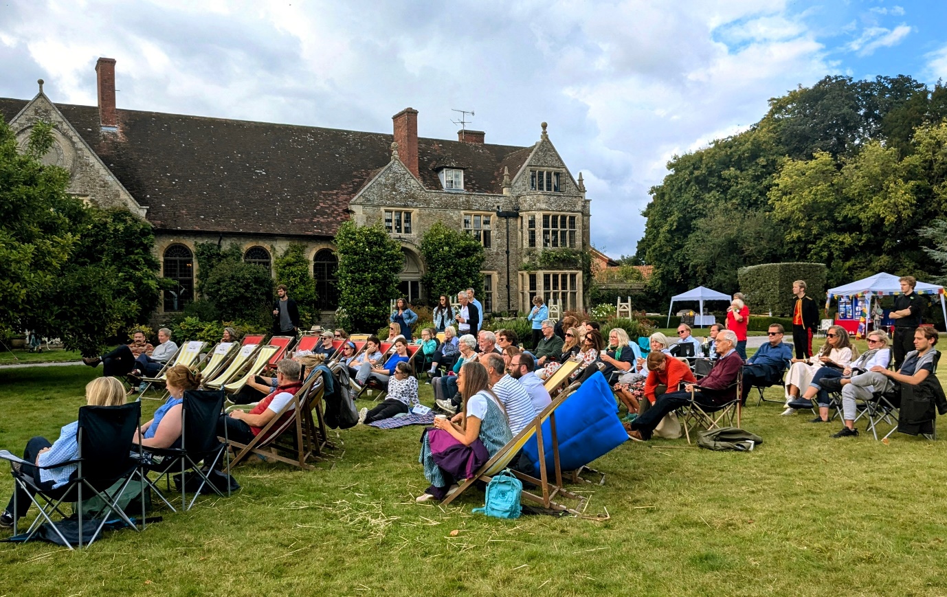 The audience on deck chairs in the garden, watching Act 2